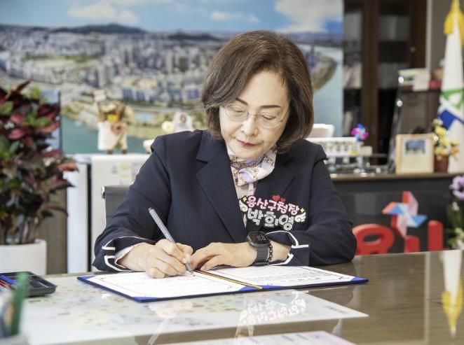 박희영 용산구청장이 지역경제 활성화를 위한 특별신용보증지원 업무협약서에 서명하고 있다
